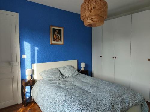 - une chambre avec un mur bleu et un lit dans l'établissement Appartement calme et lumineux à Clichy, à Clichy