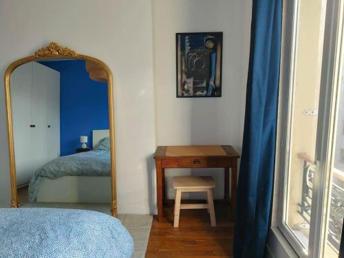 - une chambre avec un miroir, une table et un lit dans l'établissement Appartement calme et lumineux à Clichy, à Clichy