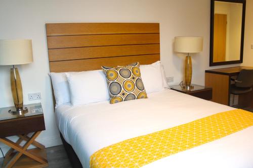 a bed in a hotel room with two lamps at Maze apartments and rooms Free parking in Hull