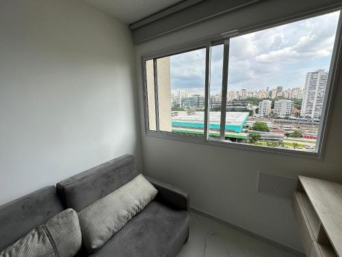a couch in a room with a large window at TrevizZo Allianz Parque in Sao Paulo