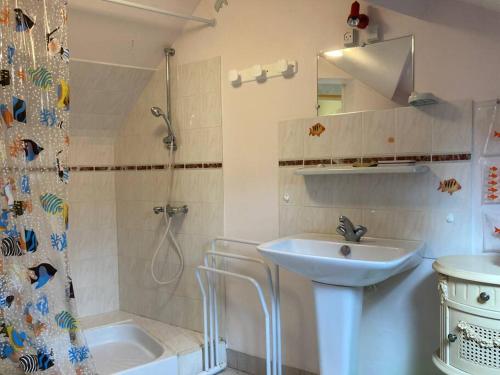 Un baño con lavabo, ducha y bañera. en Maisonnette 3 chambres - Plage de Belmont, en La Turballe