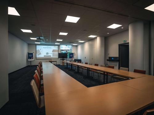 a conference room with tables and chairs and a screen at Novotel Lille Centre Grand Place in Lille