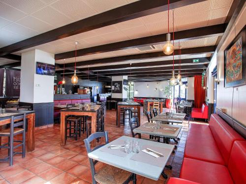 un restaurant avec des tables et des chaises ainsi qu'un bar dans l'établissement ibis Marseille Centre Gare Saint Charles, à Marseille