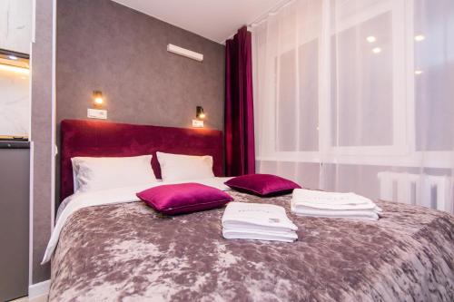 a bedroom with a large bed with purple pillows at MYFREEDOM Апартаменти пр-т Воскресенський in Kyiv