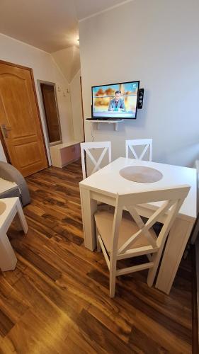 a living room with a white table and a tv at Apartments Katarina in Zlatibor