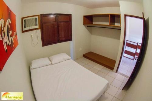 Un pequeño dormitorio con una cama blanca en una habitación en Privê Maragogi Residence en Maragogi