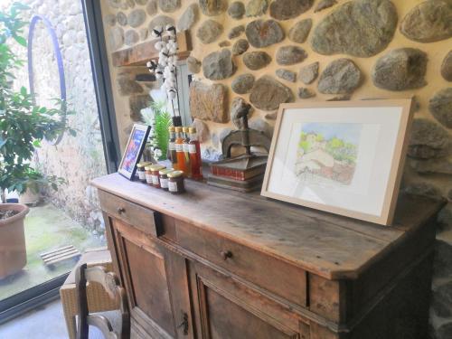 a wooden dresser in a room with a stone wall at La Secrète in Vogüé