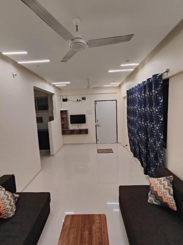 a living room with two couches and a table in a room at Gandhi Villa in Daman