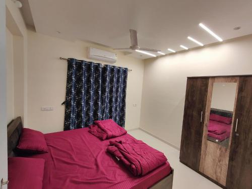Zimmer mit einem Bett, einem Spiegel und einem Fenster in der Unterkunft Gandhi Villa in Daman
