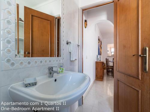 La salle de bains est pourvue d'un lavabo et d'un miroir. dans l'établissement Akisol Albufeira Sunny, à Roja- Pé