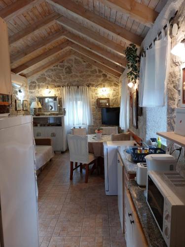 una cocina con electrodomésticos blancos y una mesa en una habitación en Holiday Home Kamenice, en Gruda