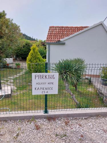 a sign on a fence in front of a house at Holiday Home Kamenice in Gruda