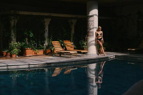 a woman in a bikini standing next to a swimming pool at Heybe Hotel & Spa in Goreme