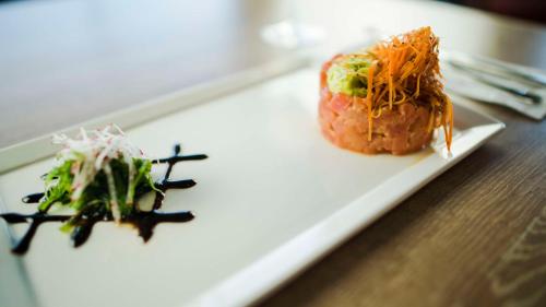 a white plate with sushi and vegetables on a table at Hyatt Place Managua in Managua