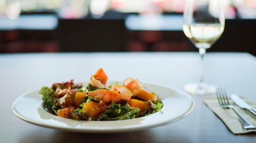 a plate of food on a table with a glass of wine at Hyatt Place Managua in Managua