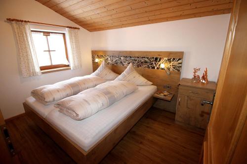 ein Schlafzimmer mit einem Bett mit zwei Kissen darauf in der Unterkunft Schifterhof Ruhpolding in Ruhpolding