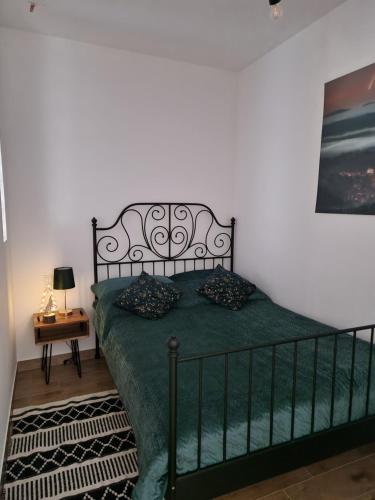 um quarto com uma cama com um edredão verde em Dusznickie Apartamenty z widokiem em Duszniki Zdrój