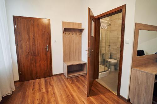 uma casa de banho com um WC e uma porta de madeira em Hotel Lilia em Włoszczowa