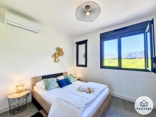 - une chambre avec 2 lits et une fenêtre dans l'établissement Villa Clokassya - 60m² avec piscine - Saint-Pierre, à Saint-Pierre