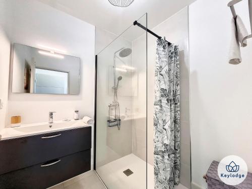 een witte badkamer met een wastafel en een douche bij Villa Clokassya - 60m² avec piscine - Saint-Pierre in Saint-Pierre