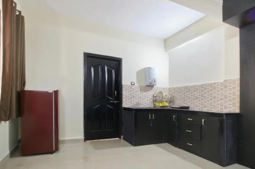 uma cozinha com armários pretos e uma porta preta em APERTEMEN PERMATA INDAH em Kotabatu
