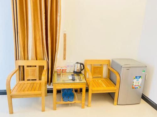 d'une table, de deux chaises et d'un petit réfrigérateur. dans l'établissement Hotel Aloha 2, à Ninh Hải