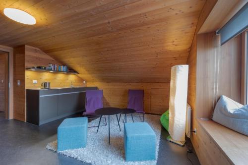 a kitchen with purple chairs and a table in a room at UnderDach in Andermatt