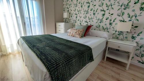 a bedroom with a bed with green and white wallpaper at RentalSevilla en Jardines de Murillo in Seville