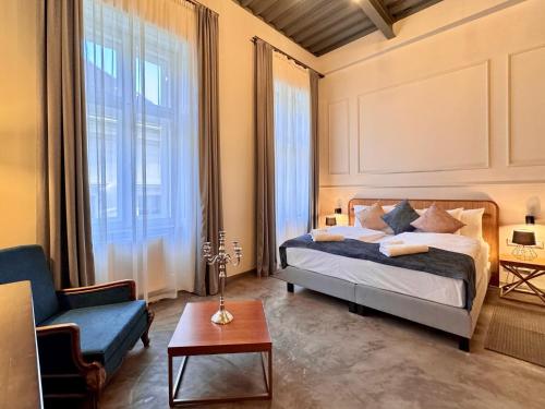 ブダペストにあるBazaar Boutique Residenceのベッドルーム1室(ベッド1台、椅子、テーブル付)