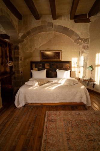 a bedroom with a large bed in a stone wall at Seki Cave Suites in Goreme