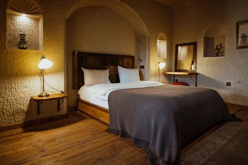 a bedroom with a large bed and two lamps at Seki Cave Suites in Goreme
