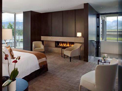 a hotel room with a bed and a fireplace at Fairmont Pacific Rim in Vancouver