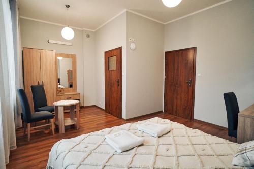 1 dormitorio con 1 cama, mesa y sillas en Hotel Lilia en Włoszczowa