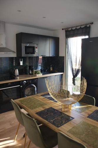 une cuisine avec une table en bois et des chaises ainsi qu'une salle à manger dans l'établissement Apt 6 personnes terrasse vue parc, à Dunkerque