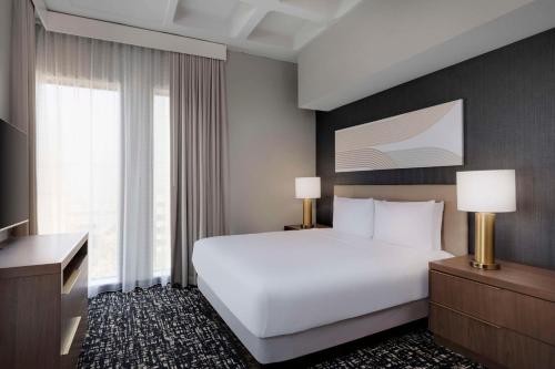 a hotel room with a white bed and a desk at Hyatt House LAX Century Blvd in Los Angeles