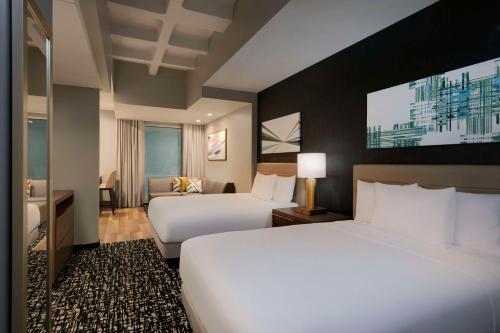 ロサンゼルスにあるHyatt House LAX Century Blvdのベッド2台と薄型テレビ付きのホテルの部屋