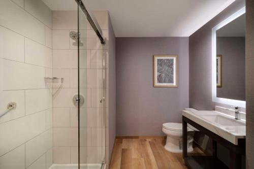 a bathroom with a shower and a toilet and a sink at Hyatt Place LAX/Century BLVD in Los Angeles
