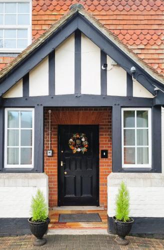 a black and white house with a wreath on the door at Royal Swan, Ashley Manor - B&B in Shedfield