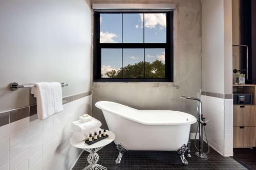 a white bath tub in a bathroom with a window at Hotel Nyack, a JdV by Hyatt Hotel in Nyack