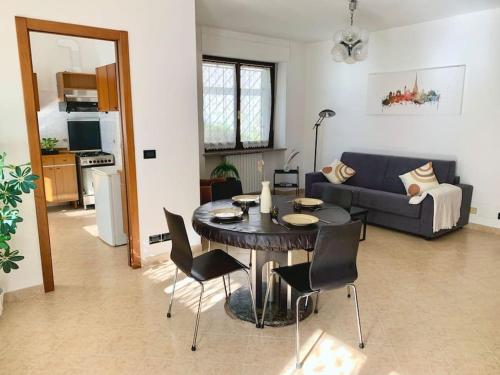 uma sala de estar com uma mesa e cadeiras e um sofá em Appartamento indipendente a Mirafiori Sud em Turim