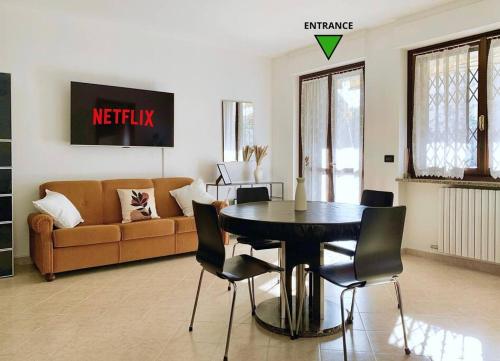 ein Wohnzimmer mit einem Tisch und einem Sofa in der Unterkunft Appartamento indipendente a Mirafiori Sud in Turin