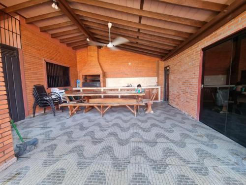 patio con mesa, sillas y pared de ladrillo en Hospedaje Confortable en Luque en Luque