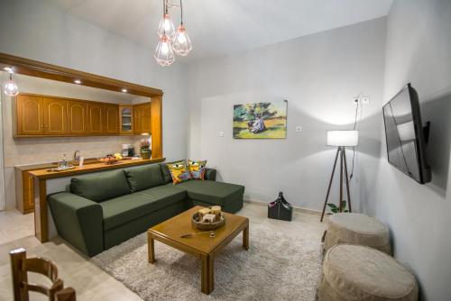 Trikala Home في تريكالا: غرفة معيشة مع أريكة خضراء وطاولة