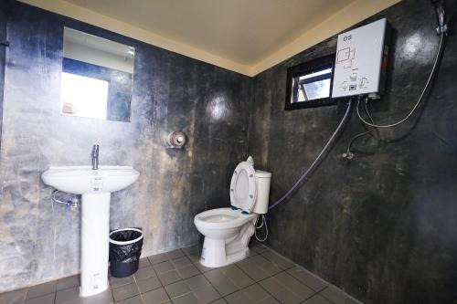 La salle de bains est pourvue de toilettes et d'un lavabo. dans l'établissement สวนไร่รุ่งอรุณ, à Ban Na Pa Paek
