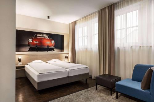 a bedroom with a bed and a red car on the wall at Vienna House Easy by Wyndham Osnabrück City & Apartments in Osnabrück