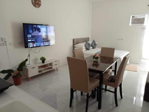 1 dormitorio y sala de estar con mesa de comedor. en M&M Royal Oceancrest Mactan, en Sudtungan