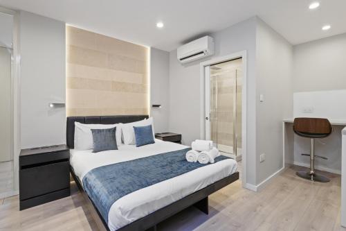 a bedroom with a large bed and a desk at Studio Flat West End Lane in London