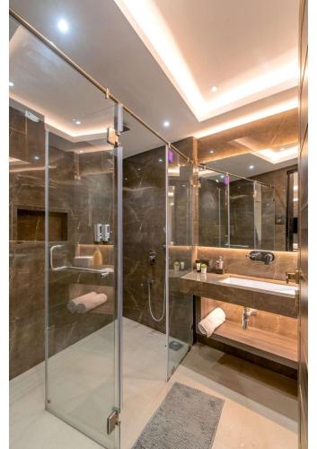 uma casa de banho com uma cabina de duche em vidro e um lavatório. em Nemaan villa em Dhantoli