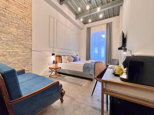 a bedroom with a bed and a couch and a tv at Bazaar Boutique Residence in Budapest