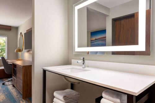 a bathroom with a sink and a mirror at La Quinta Inn by Wyndham Columbia NE Fort Jackson in Columbia